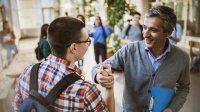 Photo of high school teacher and student clasping hands