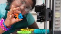 Photo of student working with 3D printer