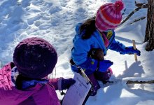 Two elementary students taking snow measurements