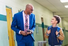 Principal and elementary student walking down the hall together