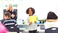 Elementary student reads from a project in class