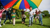 Elementary students playing with a parachute outside