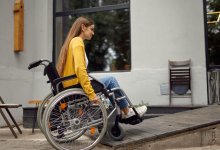 Teenager in a wheelchair wheeling herself up a ramp