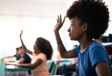 Black student raises her hand in class