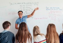 Photo of teacher and students in front of white board