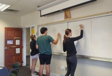 Photo of high school students at board in classroom