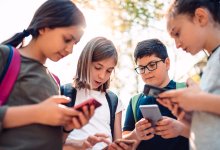 Four middle school students on their smartphones