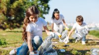 Photo of elementary students cleaning up garbage in park