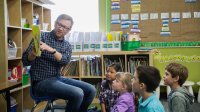 Photo of elementary teacher reading book to students