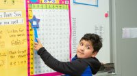 Elementary boy points out Korean letters on a chart