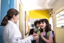 Photo of middle school teacher greeting student