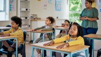 Photo of elementary school students meditating in class