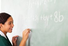 Photo of student doing math problem on chalk board