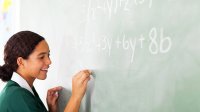 Photo of student doing math problem on chalk board