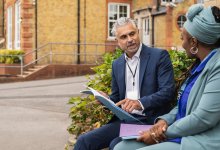 Two colleagues talk while sitting outside