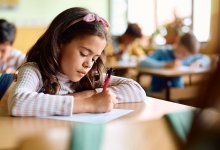Elementary student writing at her desk