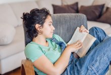 High school student reading book at home