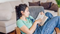 High school student reading book at home