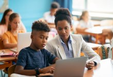 Photo of elementary teacher and student on laptop