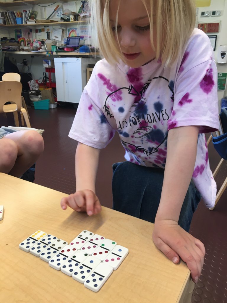 Student working with dominoes in class