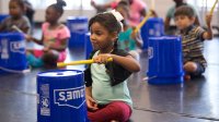 Elementary students using bucket drums