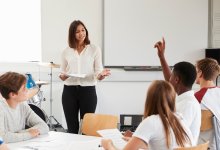 Teacher pointing to student with raised hand