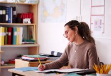 Photo of teacher writing at her desk