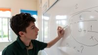 Student working on math problems on a whiteboard