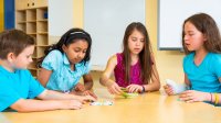 Elementary students playing a card game