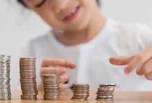 Photo of child making stacks of coins
