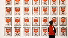 Young child standing in front of Andy Warhol's Campbell Soup art