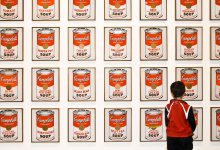 Young child standing in front of Andy Warhol's Campbell Soup art