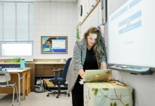 Photo of teacher working with tech in classroom