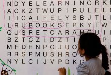 Photo of elementary student doing a word search on a whiteboard