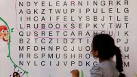 Photo of elementary student doing a word search on a whiteboard