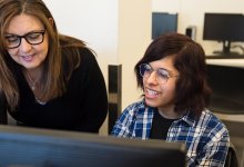 Teacher helping student at computer