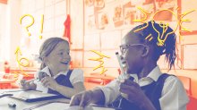 Two young students happily interact in a classroom