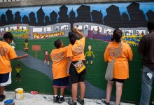 Photo of middle school student painting wall mural