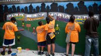 Photo of middle school student painting wall mural