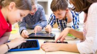 Photo of elementary teacher and students on ipads in classroom