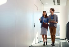 Two adults walking down a hallway