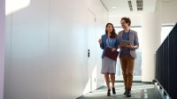 Two adults walking down a hallway