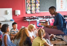 Elementary teacher reading book to students