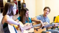 Photo of high school students playing guitars