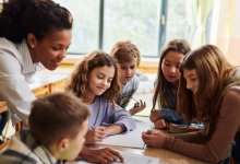 Photo of elementary school teacher working closely with students