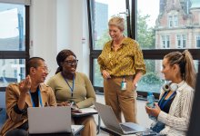 Photo of a group of teachers at meeting with computers