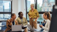 Photo of a group of teachers at meeting with computers