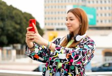 Photo of teenager taking selfie outside