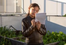 A student writes in a nature journal in an urban school garden