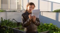 A student writes in a nature journal in an urban school garden